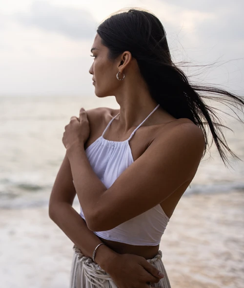 Model on a beach gazing towards the sea